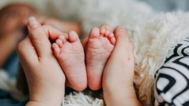 赤ちゃんの足を包む手